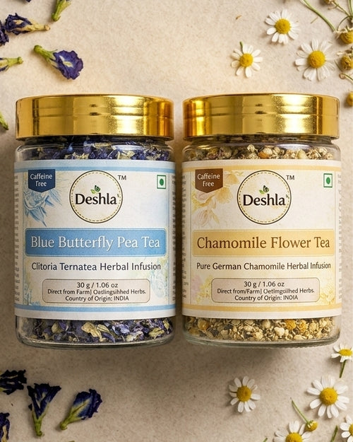 Two jars of Deshla tea, one labeled 'Blue Butterfly Pea Tea' and the other 'Chamomile Flower Tea', surrounded by flowers on a light background.