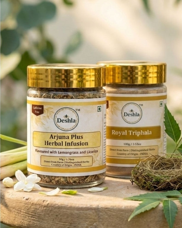 Two jars of Deshla herbal products on a wooden surface with greenery in the background