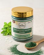 Jar of Deshla Natural Green Spirulina Powder with a spoonful of powder and green leaves on a light background