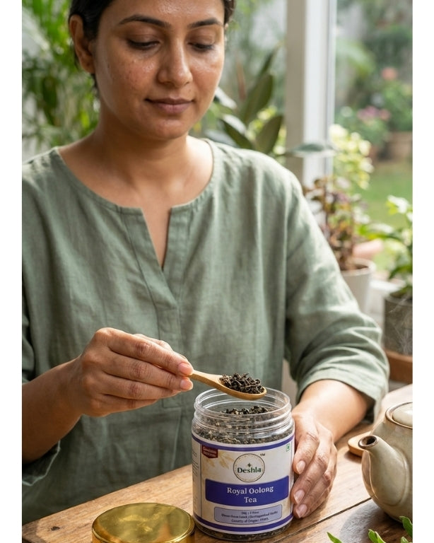 Woman scooping tea from a jar with a wooden spoon in a home setting